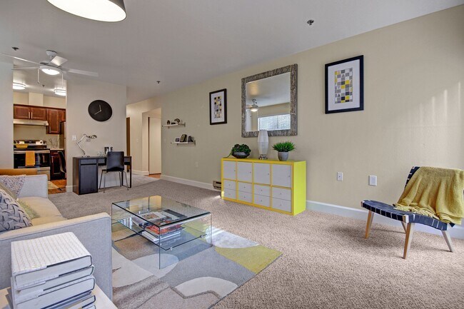 Living room with couch, desk, and view into the kitchen