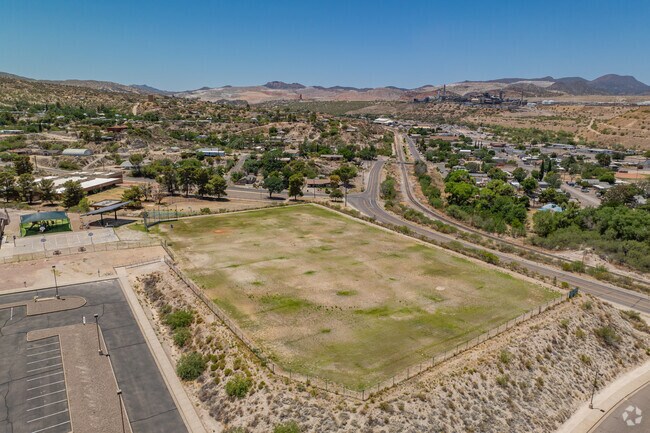 The school sits on an elevated lot, with open land surrounding Dr. Charles A. Bejarano Elementary School on all sides.