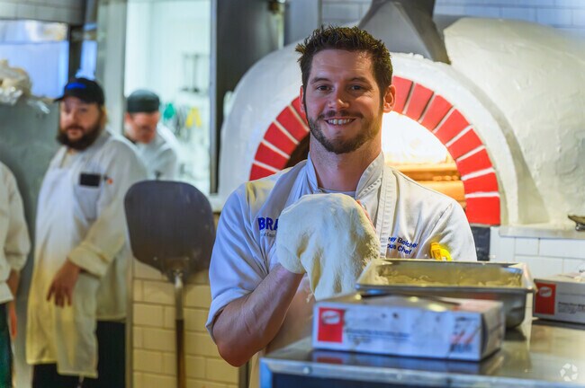 A friendly chef at Bravo Italian Kitchen makes pizza by hand in Northside Lansing.