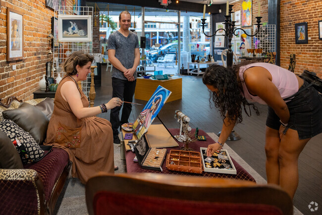 A local artist chats with patrons as she paints a new work of art in Downtown Fort Myers.