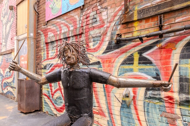 Whimsical metal art of David Grohl in an alley in Historic Perkins.