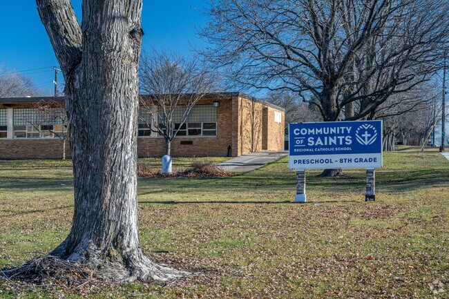 Community of Saints Regional Catholic School is surrounded by large trees.