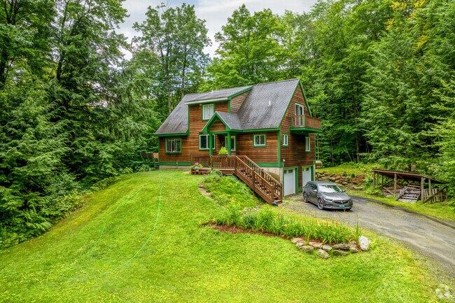 A rustic brown wooden home with green accents matches the vibrant surroundings of Bolton Valley.