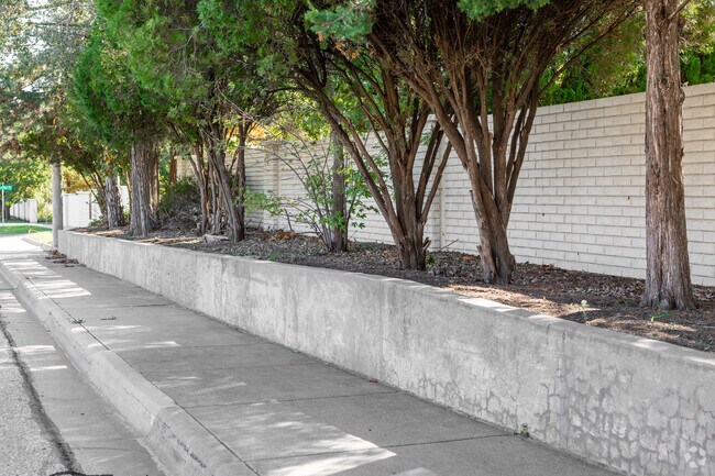 The boarder of Bonnie Brae is surrounded by a white brick fence and a sidewalk.