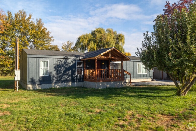 Manufactured home with porch sits on a private lot in Gleed.
