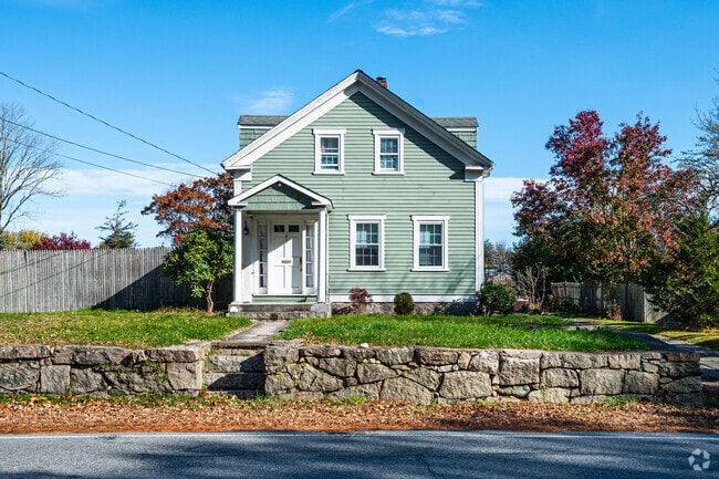 On an elevated property space is this pastel green American Foursquare home.