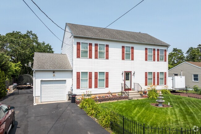 This Colonial Revival home in Browns Mills has plenty of curb appeal with it landscaping and fountain.