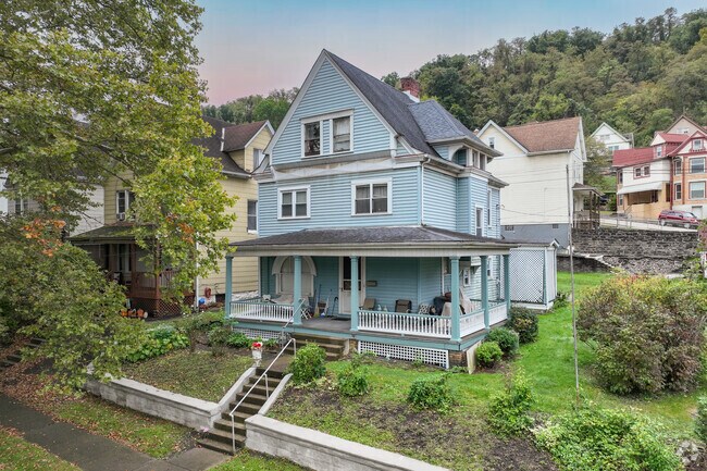 A charming, pastel Victorian home with a walk-up porch in Wilmerding.
