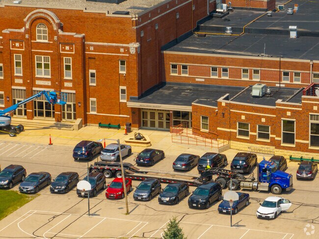 Historic red brick facade of Central School with construction equipment in Lake Geneva.