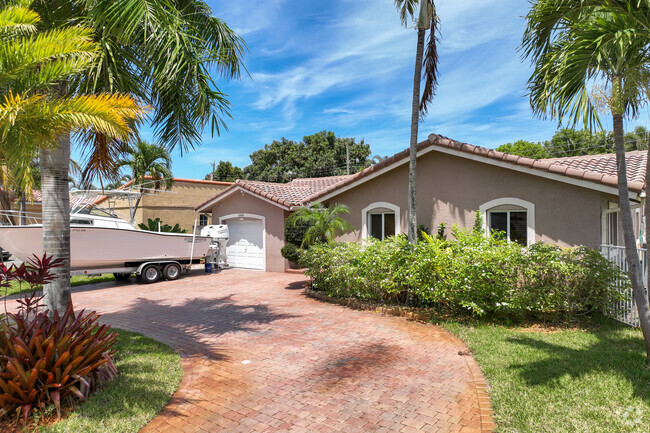 Traditional single-family home with a boat in the front yard in Boulevard Park Isles.