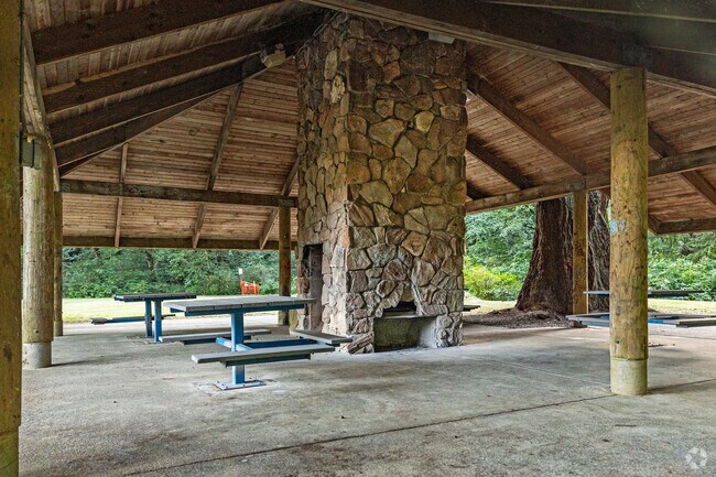 A covered cabin-like gazebo provides shade and a fire pit at Stewart Memorial Park in Aberdeen.