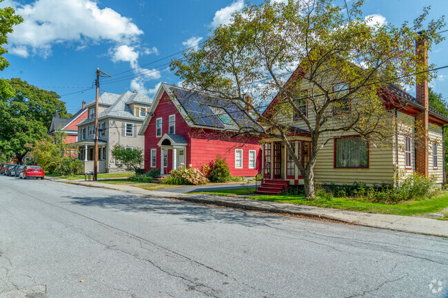 A row of colorful single family homes in The Meadow are on a quiet street with very small yards.