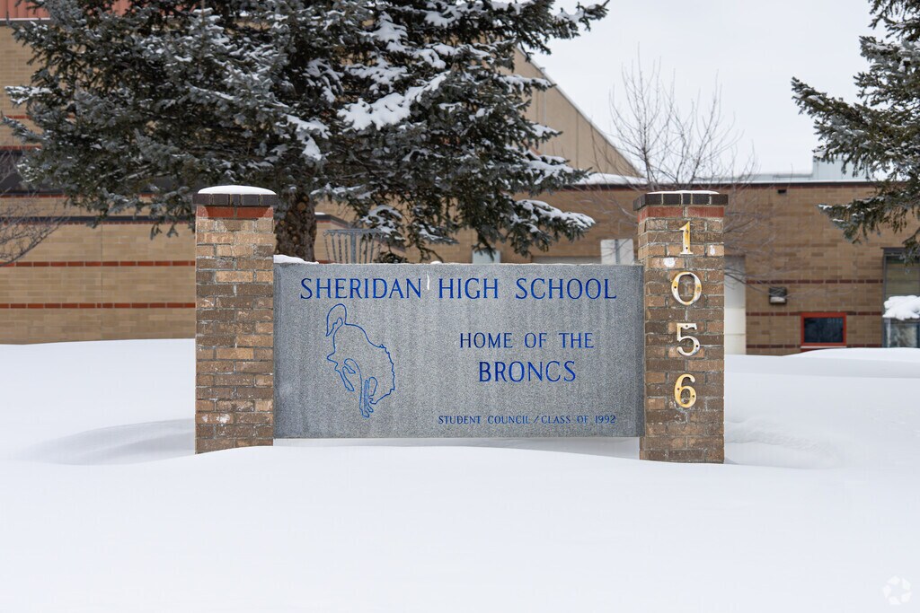 A stone sign welcomes students to Sheridan High School.