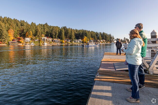 Onlookers watch the harbor traffic as it goes by near Tides Tavern.