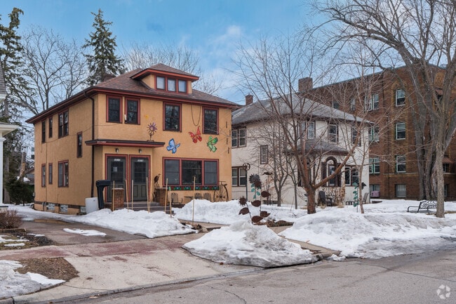 A stucco foursquare style home with a butterfly mural.