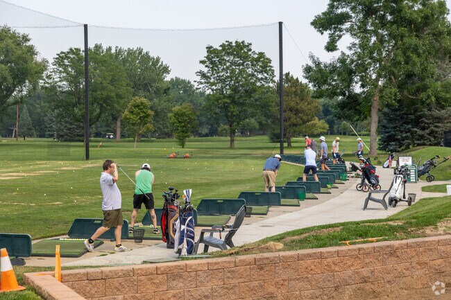 Residents warm up for a day on the links on the driving range of Flatirons Golf Course.