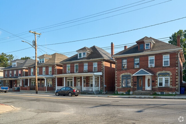 American Four-Square style duplex homes line a busy street in West End.