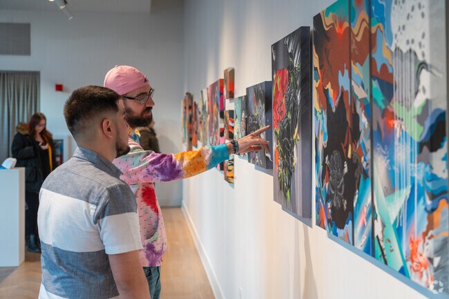 Artist Raul Rodea discusses his exhibit at the Artesan Gallery during Aurora's 1st Friday event.