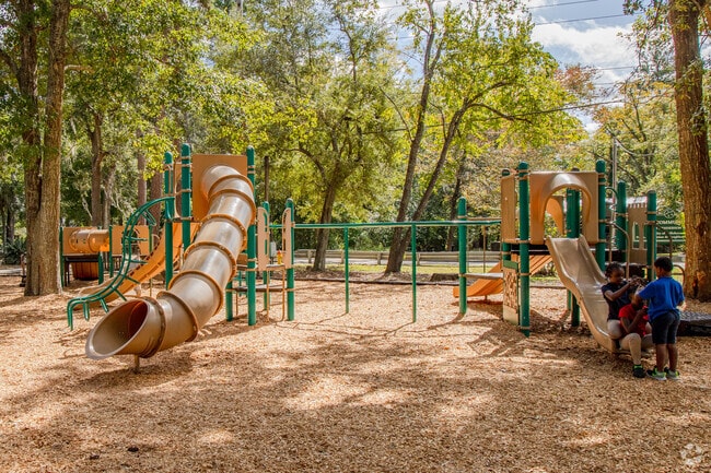 Macon Community Park playground entrance leads to swings, slides and shaded seating.