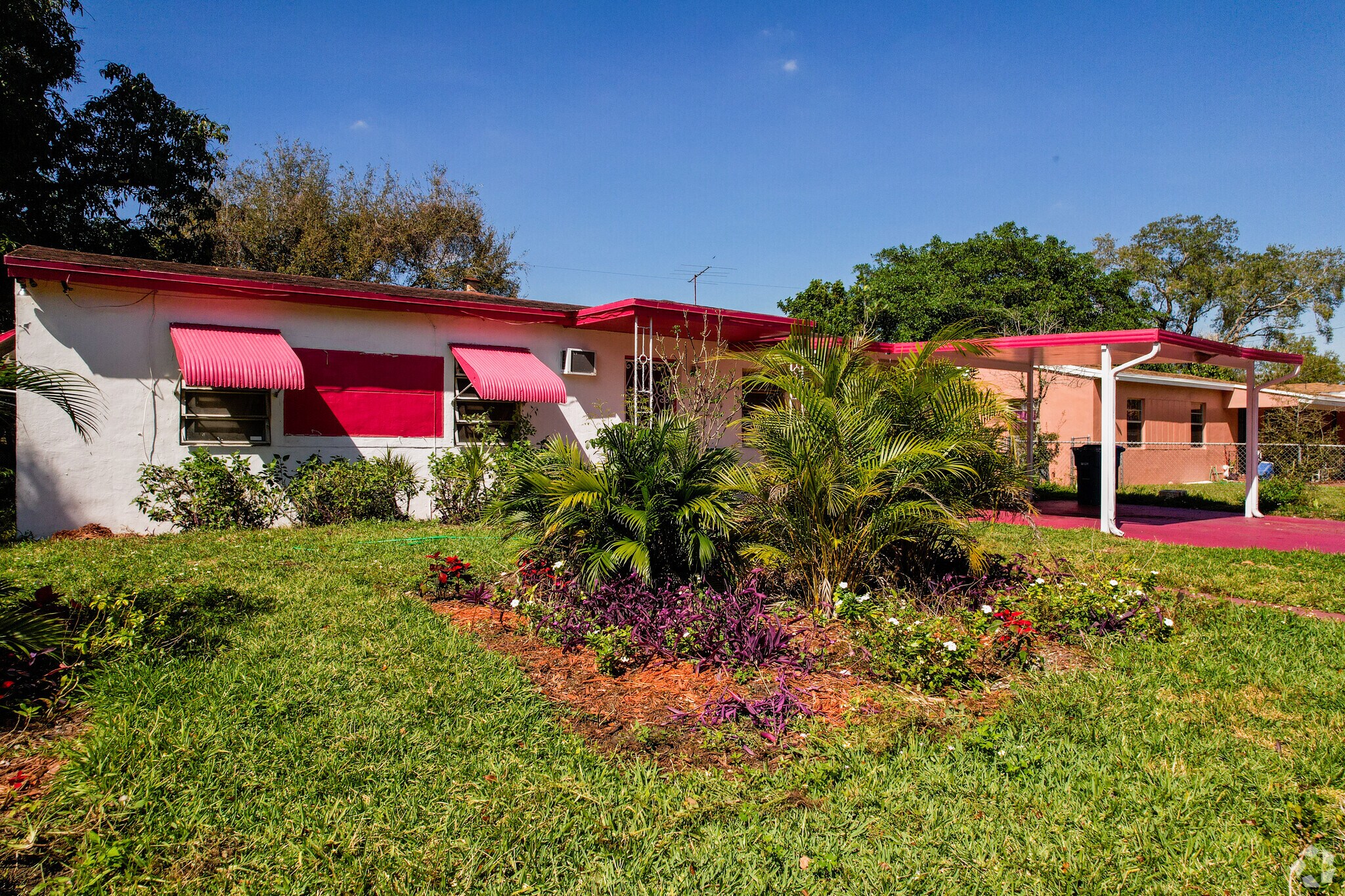 Single-story home with lush greenery in the front yard in Bunche Park.