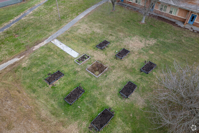There is a small raised bed garden in the yard at Halls Cross Roads Elementary School.