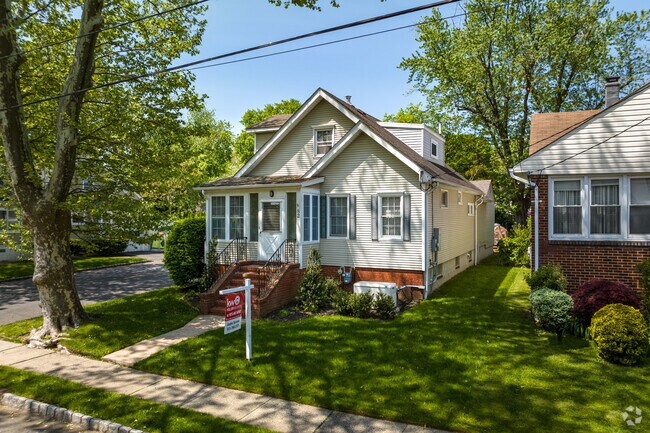 A charming cape cod style home partially shaded from the tree lined street in Springfield, NJ.
