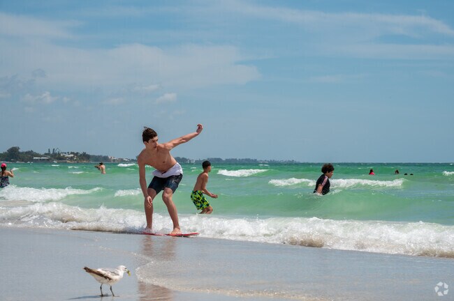 A young skim boarder glides along the smooth shores of Siesta Beach.