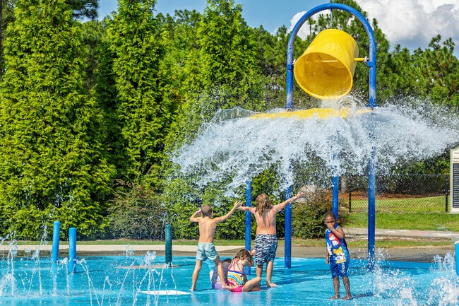 Children splash and play as the water bucket dumps at Rassie Wicker Park in Pinehurst.