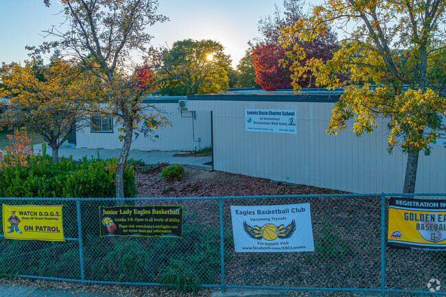 Sun sets over signage of Loomis Basin Charter School.