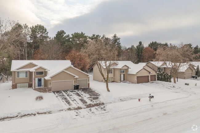 Winter view of Zimmerman single-family homes with two garages and a tree-lined backdrop near the Twin Cities.