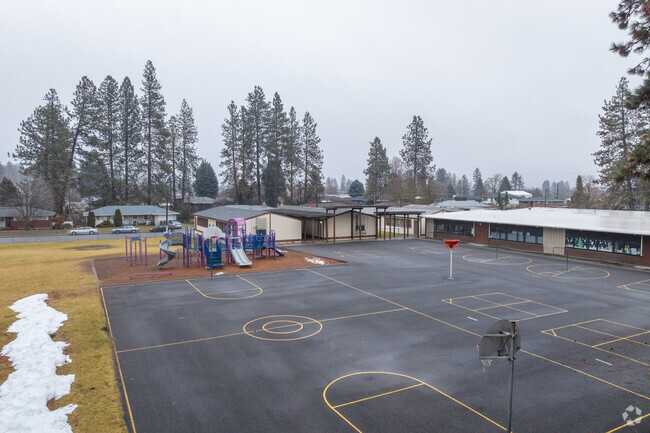 Balboa Elementary School features a large playground with basketball hoops behind the school.
