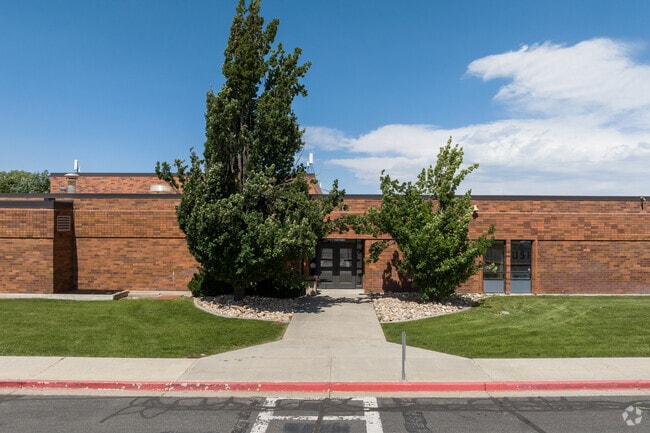 A front entrance flanked by trees at Horizon Elementary School.