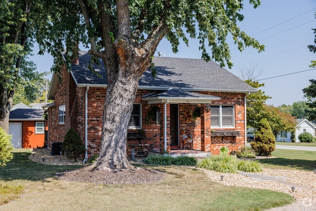 Brick homes in Aurora often feature lawns shaded by hardwood trees.