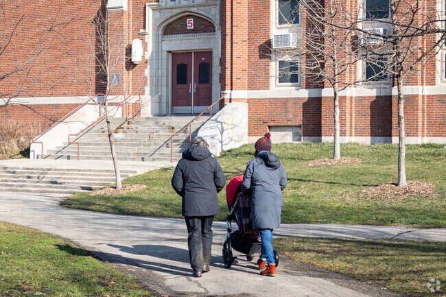 Families take leisurely strolls on the pathways by Amundsen High School.