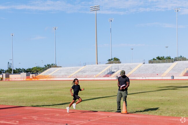 A young Fort Pierce athlete in full sprint embodying determination on the track at Lanwood park.