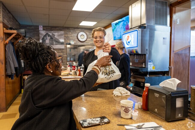 Locals pick up takeout orders at Sam’s Diner, where friendly service and homestyle cooking define the atmosphere.