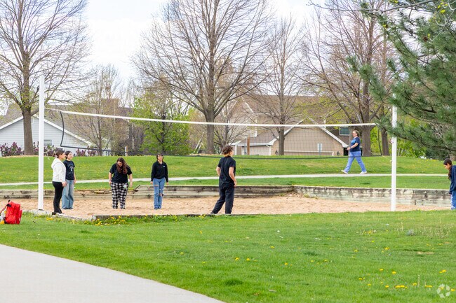 Friends enjoy a spirited volleyball match in a West Point park.
