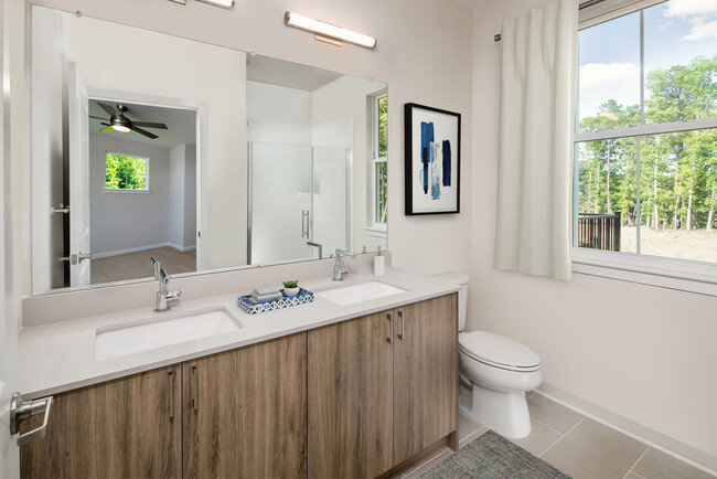 Upgrade Scheme townhome bath with oak cabinetry, grey quartz countertop, and tile flooring