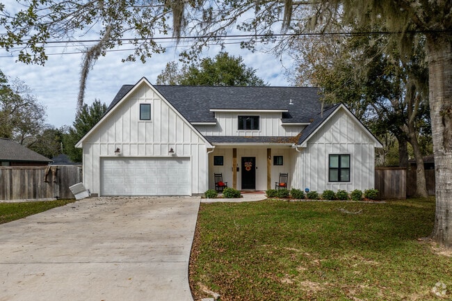 A newly built home is situated on a shaded lot on the outskirts of Sweeny, Texas.