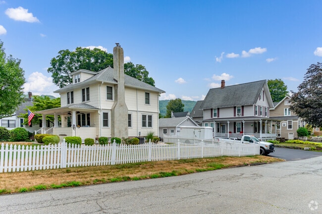 Hillburn homes with white picket fences and patriotic porches reflect classic suburban charm.