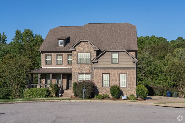 This lovely brick home in Asheton Lakes has timeless charm, with a cozy front porch, a well-kept lawn, and a welcoming feel.