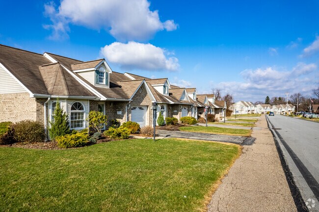 A uniform row of White Oak homes is lined by a sidewalk.