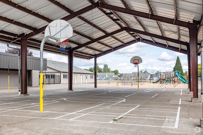 A playground and outdoor athletics area are part of the Periwinkle Elementary School campus.