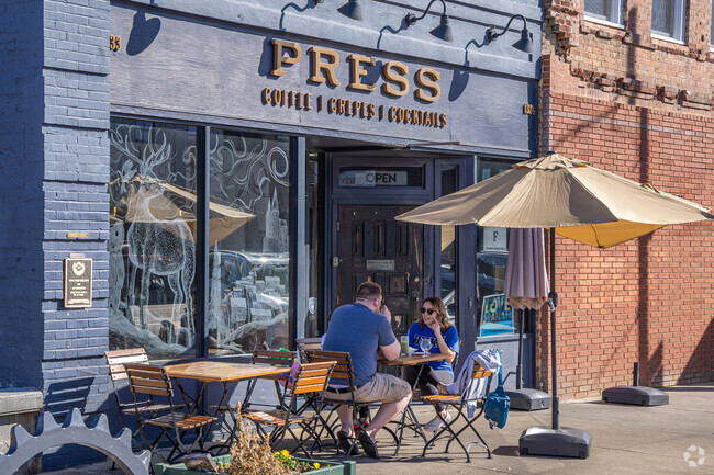 A couple savors the sunshine at Press Coffee in Graham.