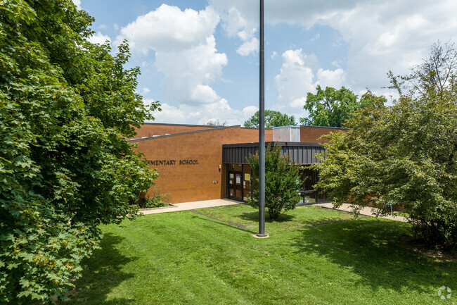 Aldan Elementary School's campus is surrounded by many mature, leafy trees.