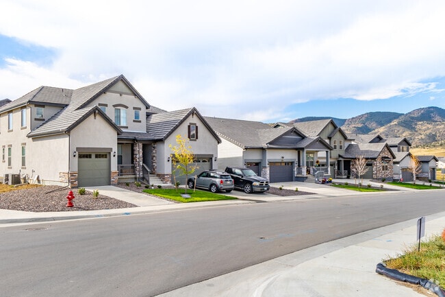 Rows of craftsman houses with stone accents and mountain views are common in Red Rocks Ranch.