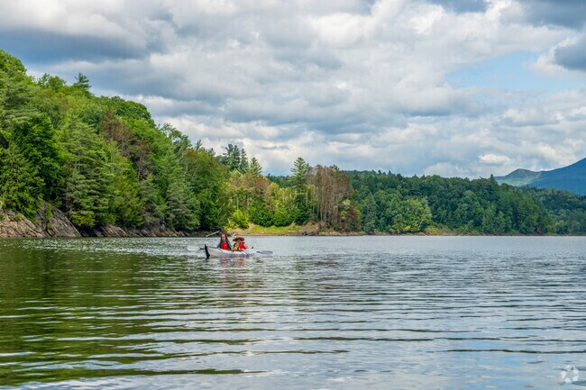 A family paddles across the shimmering surface of Waterbury Reservoir, close to Bolton Valley.