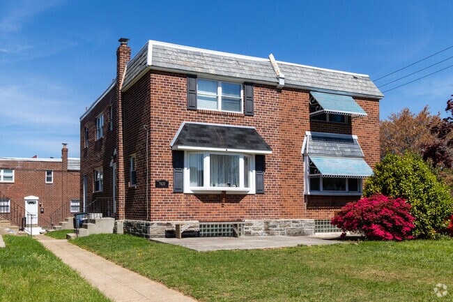 Two-story brick twin home with a neat lawn and an attached garage in the rear.