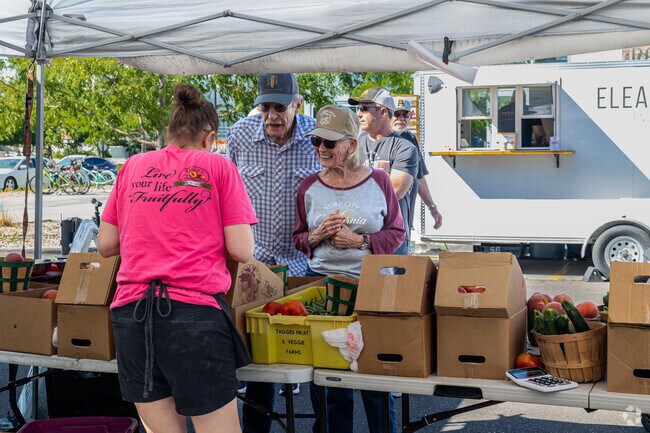 A couple buys fresh, local produce at Daybreak Farmer’s Market.
