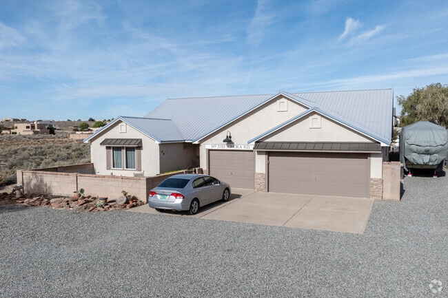 A modern stucco home with a metal roof stands on a large lot in Tampico.